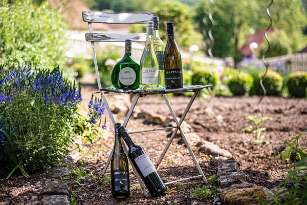 Alter Gartenstuhl, auf dem Weinflaschen platziert sind