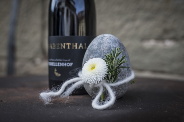 Stein Osterei mit einer Schleife und Blume dran